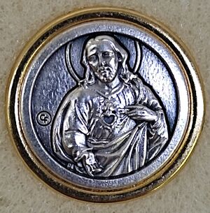 PIN REDONDO SAGRADO CORAZON PLATEADO SOBRE ESMALTE DORADO 22MM 05010062