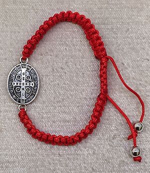 PULSERA SAN BENITO TRENZADA ROJA CON MEDALLA OVAL A DOS CARAS