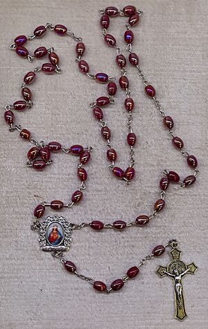 ROSARIO CRISTAL LISO OVAL ROJO 8X6MM CON CRUZ SAN BENITO